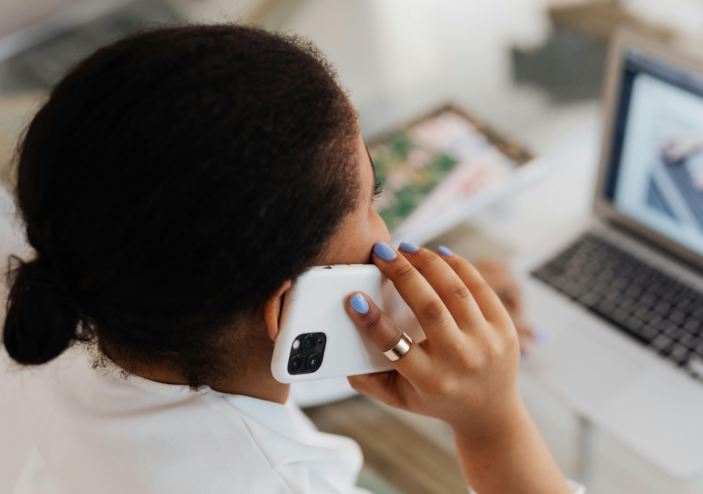 Woman sitting at a desk, on a phone call, shot from behind