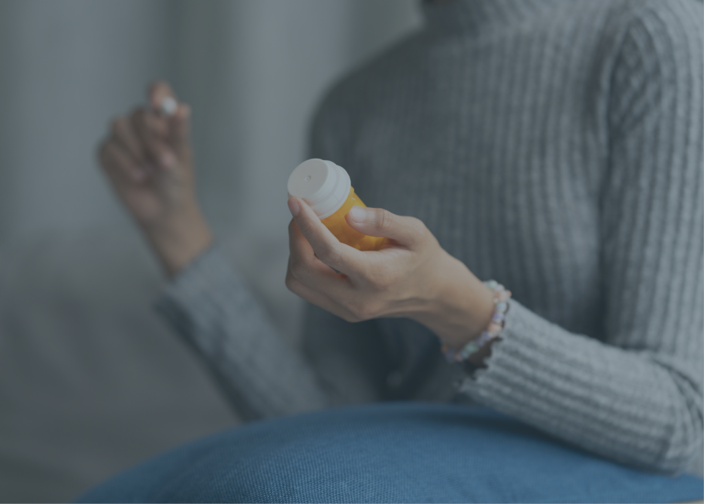 Close-up of a person holding a bottle of medication