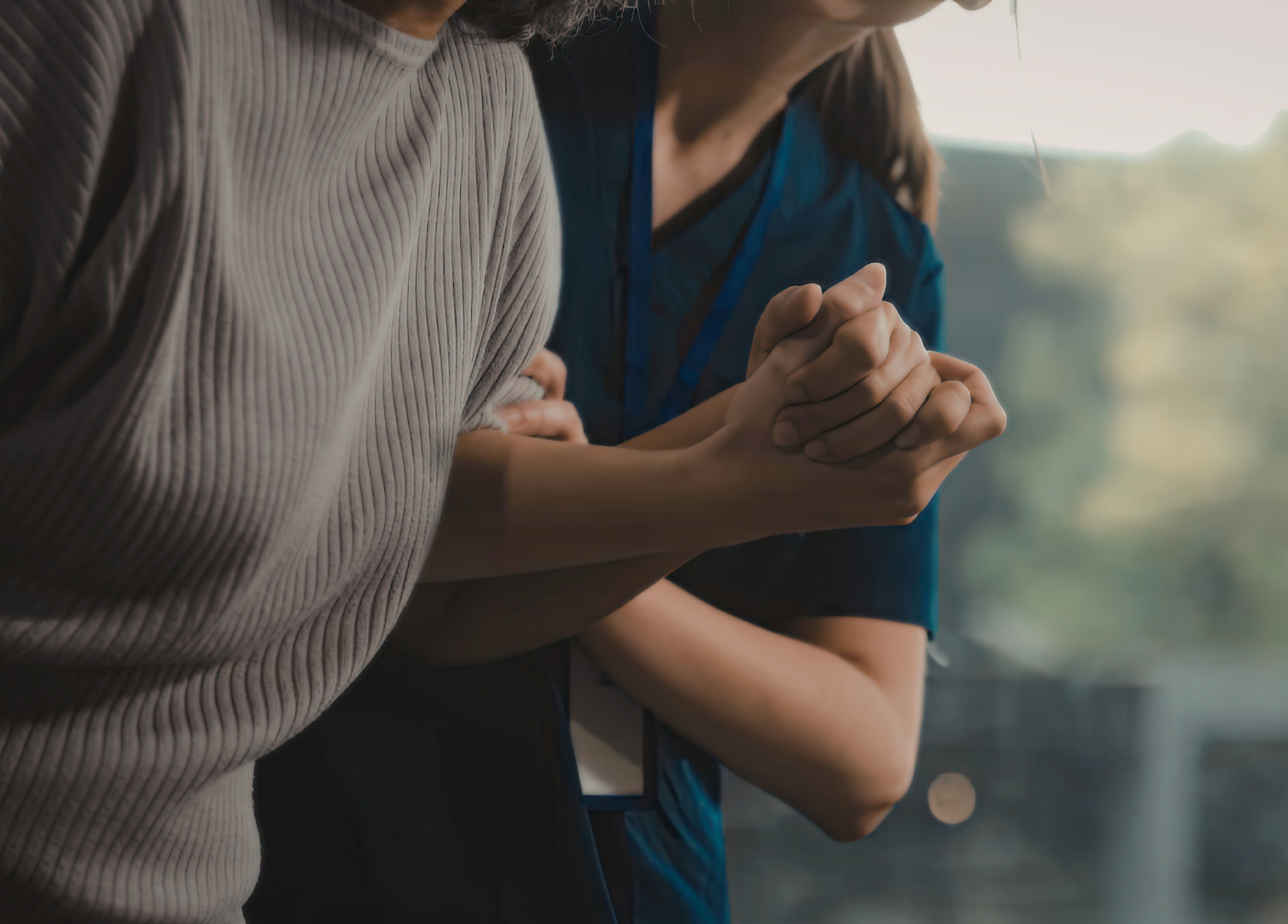 Close-up of a caregiver helping a client to stand
