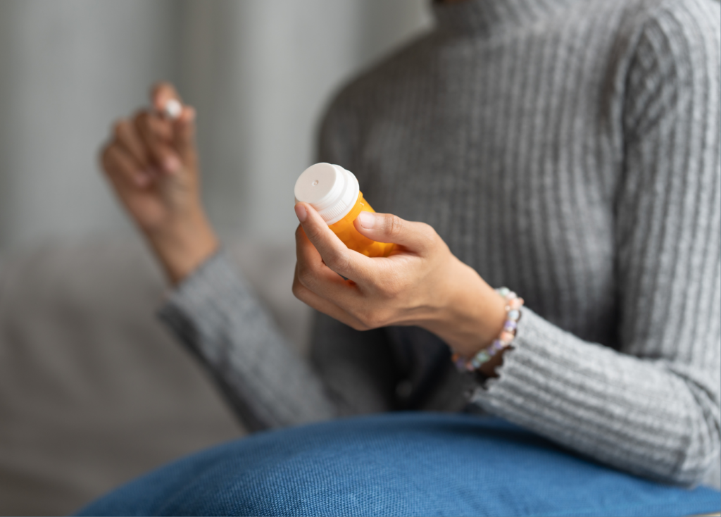 Close-up of a person holding a bottle of medication