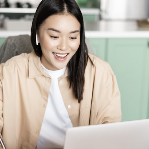 Young woman sitting in front of a laptop, on a conference call.