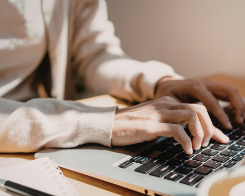 Close-up of a person typing on a laptop