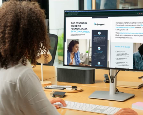 Woman sitting in front of computer reading an EVV guide